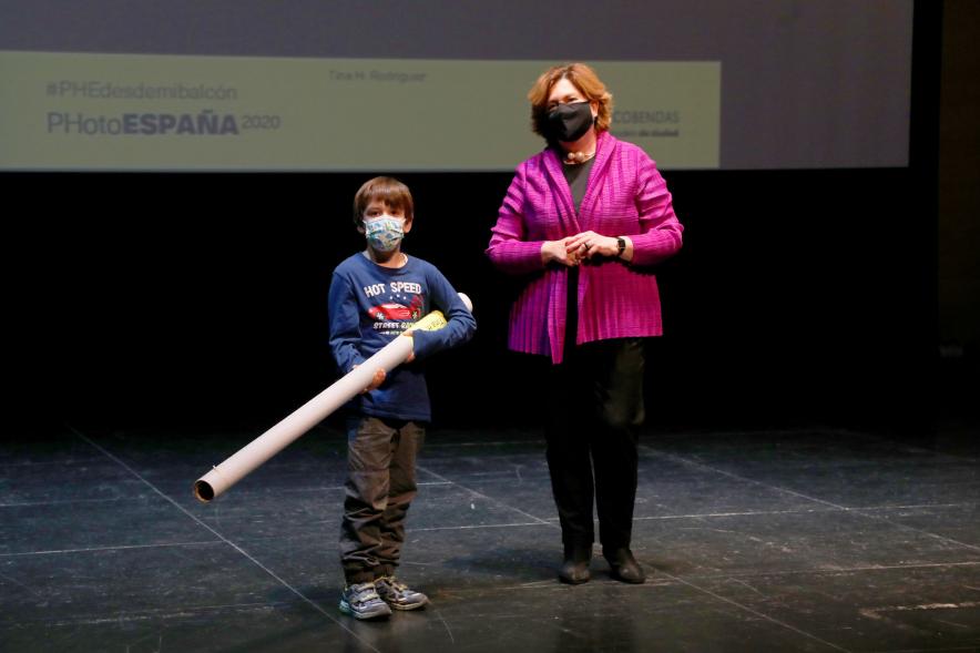 Entrega de Lonas Expo #PHEdesdemibalcon PHotoESPAÑA - Imagen de la concejala de cultura Rosario Tamayo junto a un niño después de haber entregado la lona en el escenario.
