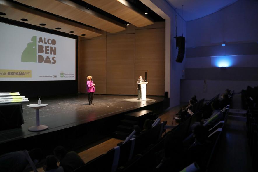Entrega de Lonas Expo #PHEdesdemibalcon PHotoESPAÑA - Imagen lejana del escenario donde podemos ver a unas personas.