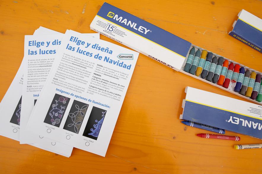Proceso Participativo Elección de Luces Navideñas 2018 - Primer plano de las tarjetas de participación junto las pinturas para colorear los diseños.