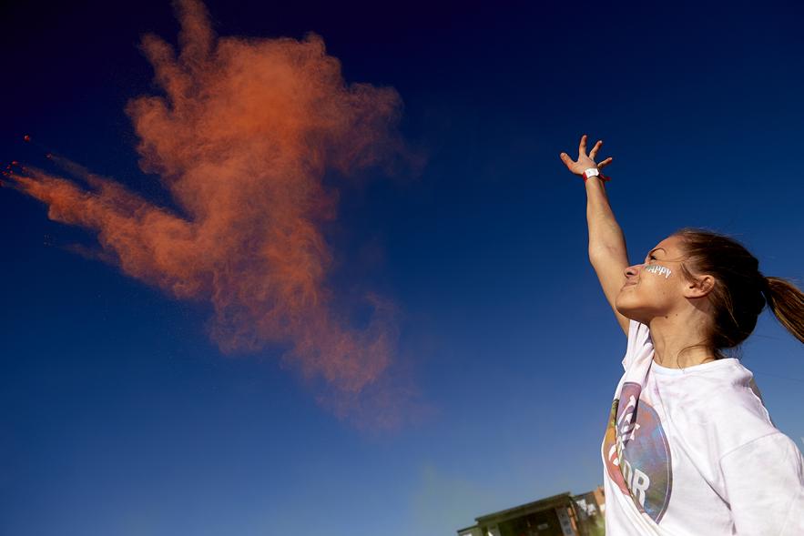 Carrera Color Run - Imagen de participantes en la carrera después de recibir polvo de color naranja.
