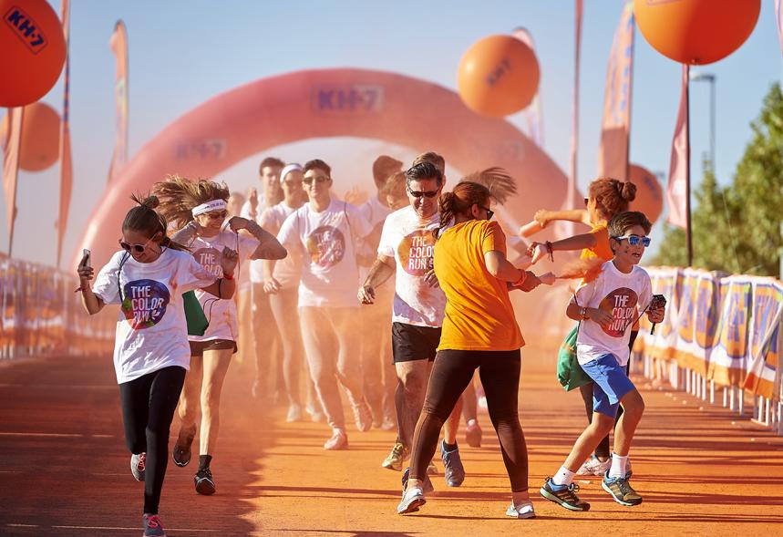 Carrera Color Run - Imagen de participantes en la carrera después de recibir polvo de color naranja.