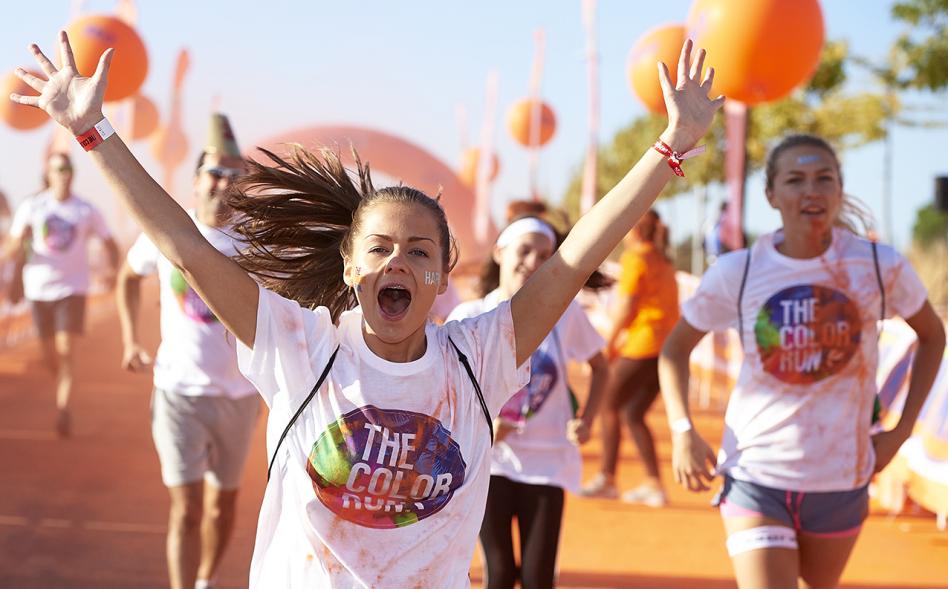 Carrera Color Run - Imagen de participantes en la carrera después de recibir polvo de color naranja.