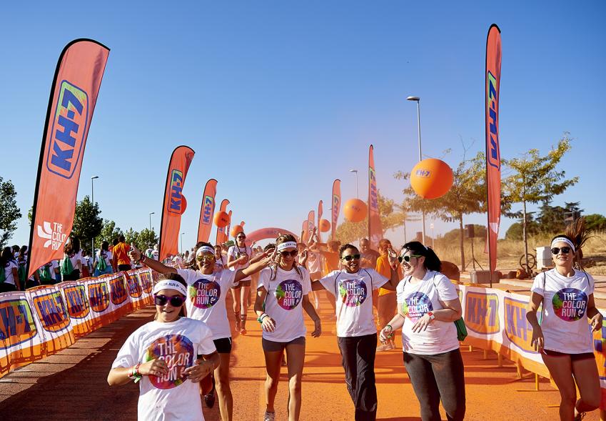 Carrera Color Run - Imagen de participantes en la carrera después de recibir polvo de color naranja.