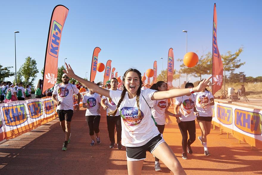Carrera Color Run - Imagen de participantes en la carrera después de recibir polvo de color naranja.