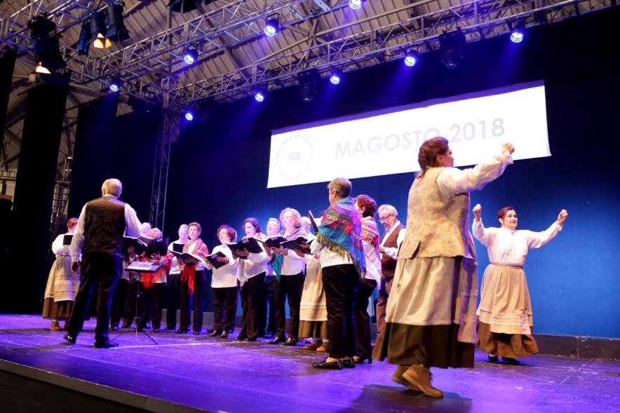 Fiesta del Magosto 2018 - Imagen de un coro cantando y una pareja de mujeres bailando una jota en el escenario.