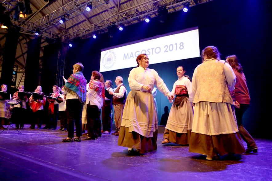 Fiesta del Magosto 2018 - Imagen de un coro cantando y unas mujeres bailando una jota en el escenario.