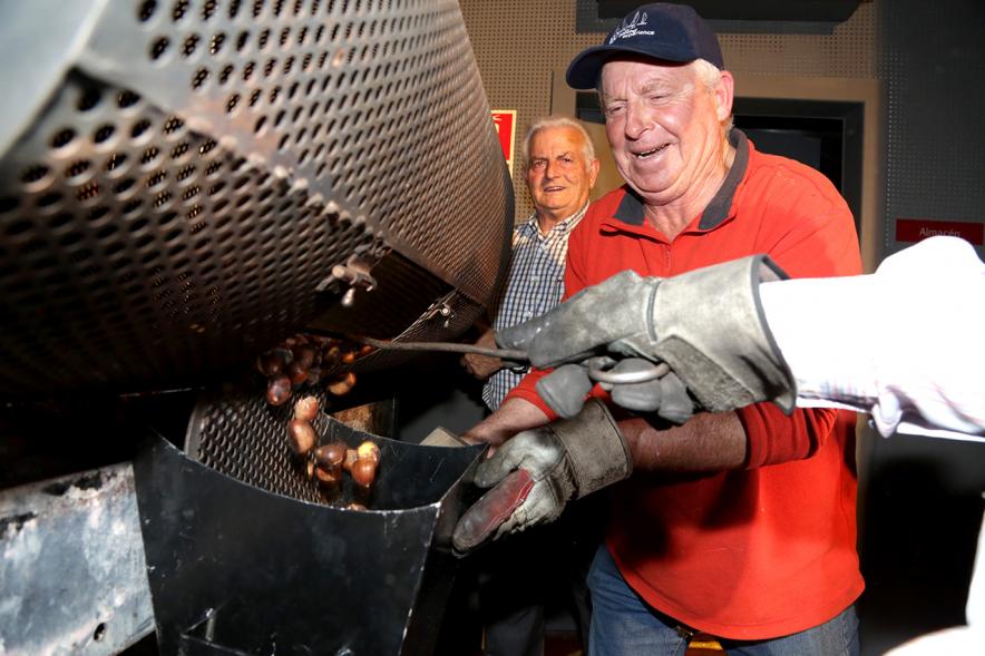 Fiesta del Mangosto de la Xuntanza de Galegos 2016 - Imagen de persona con las brasas de la hoguera, sacando las castañas asadas.