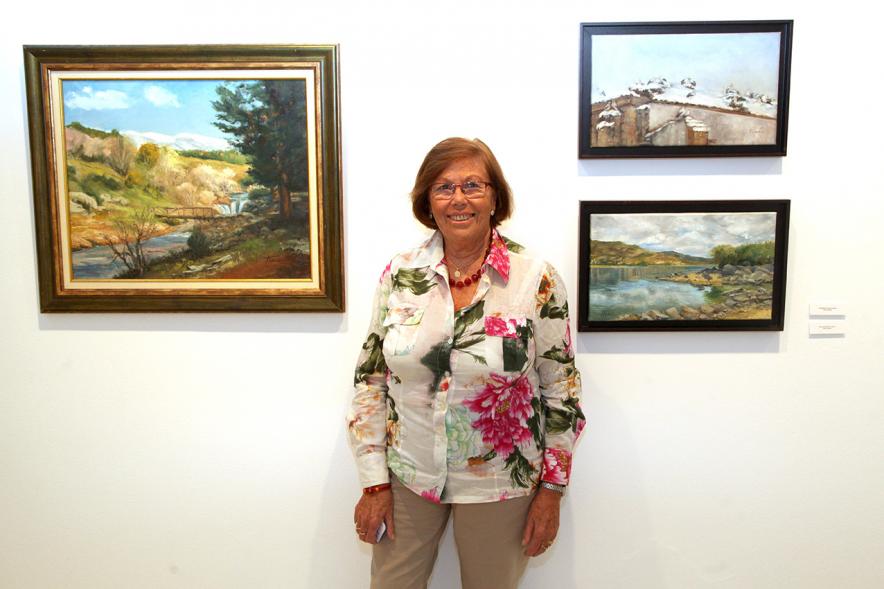 Artista posando con sus obras. 