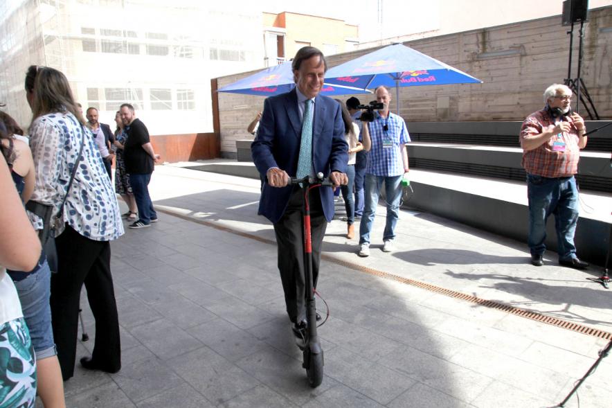 Media StartUps Alcobendas -  Imagen del alcalde probando un patinete en el exterior. 