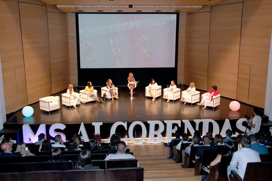 Media StartUps Alcobendas -Panorámica del escenario con las ponentes sentadas y parte del anfiteatro lleno.