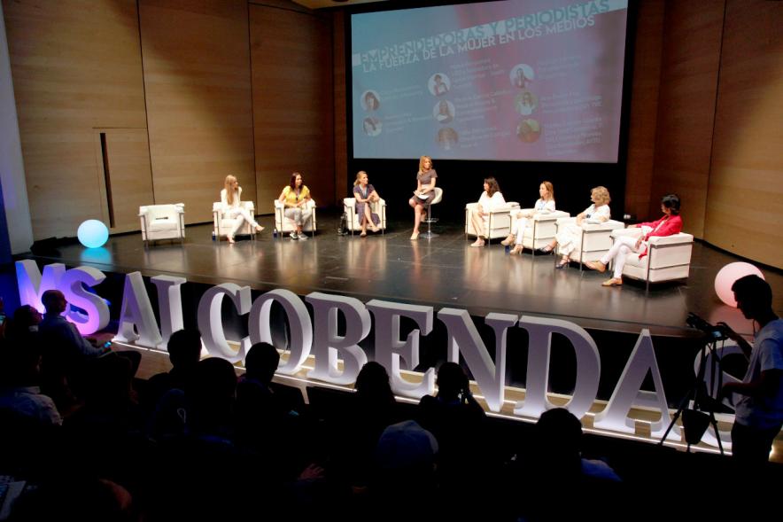 Media StartUps Alcobendas - Panorámica del escenario con las ponentes sentadas y el logotipo de la presentación.