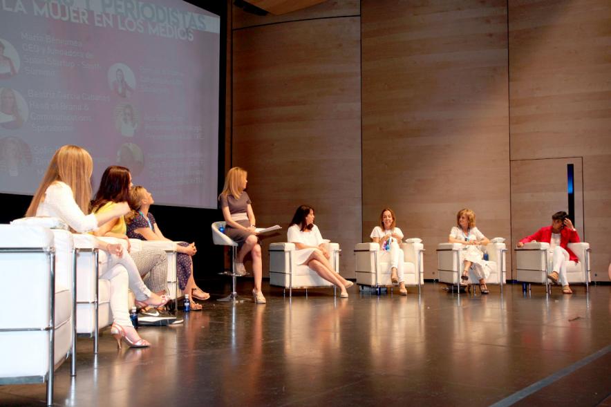 Media StartUps Alcobendas - Imagen del escenario con las ponentes de la presentación sentadas.