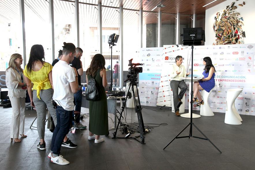 Media StartUps Alcobendas - Imagen de dos participantes sentados  y la prensa filmando.