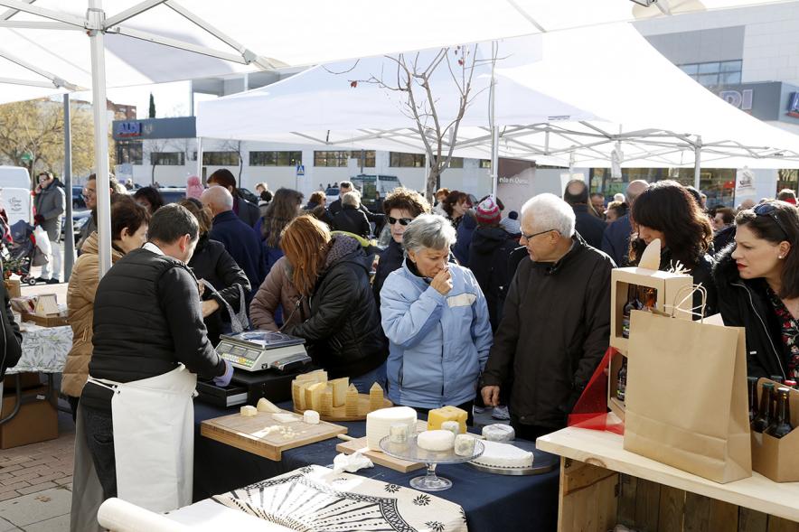Mercado Agroecológico - Imagen de personas comprando den uno de los puestos.