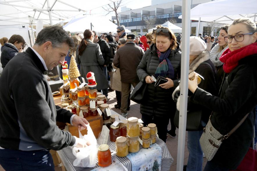 Mercado Agroecológico - Imagen de personas comprando en uno de los puestos.