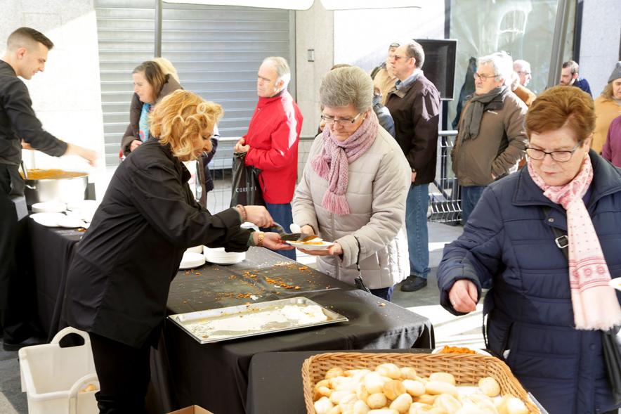 Misa, Migas y Gachas - Imagen de personas repartiendo la comida y personas cogiendo la comida.