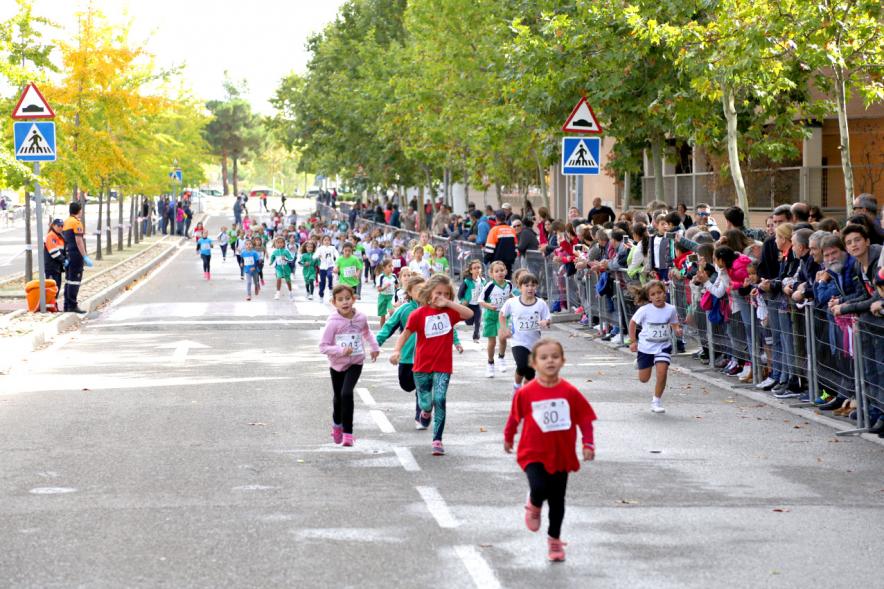 Milla Escolar 2018 -  Imagen de los corredores infantiles y el publico aplaudiendo.