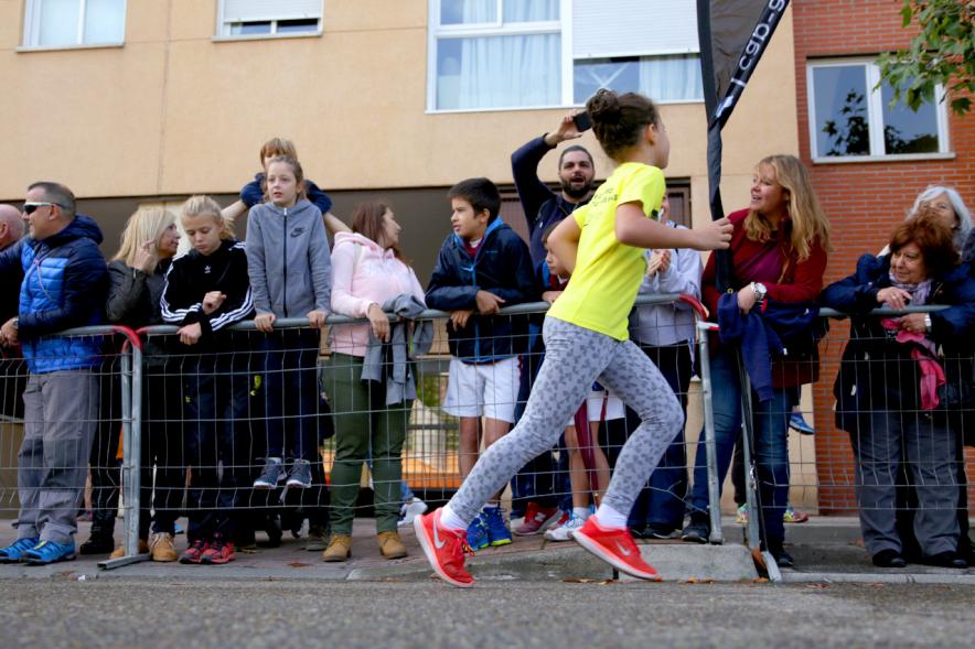 Milla Escolar 2018 - Primer plano de una niña corriendo y el público animándola.