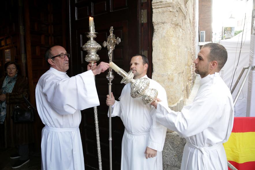 Fiestas Virgen de la Paz 2019 - Misa Mayor de la Paz - Imagen de varios sacerdotes encendiendo los cirios a la entrada de la iglesia.