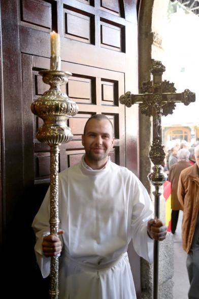 Fiestas Virgen de la Paz 2019 - Misa Mayor de la Paz - Imagen de un sacerdote sujetando un cirio en la puerta de la iglesia.