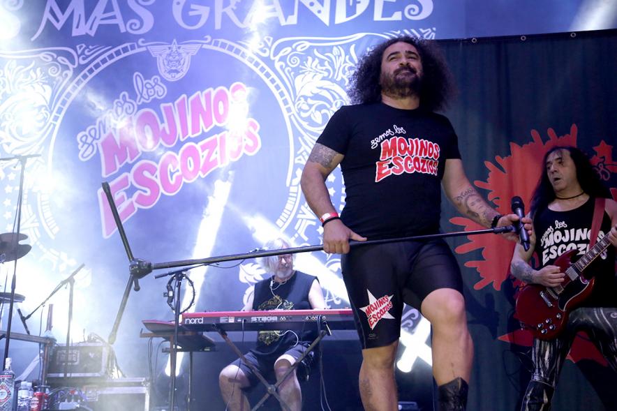Cantante al micrófono con miembros de la banda al fondo