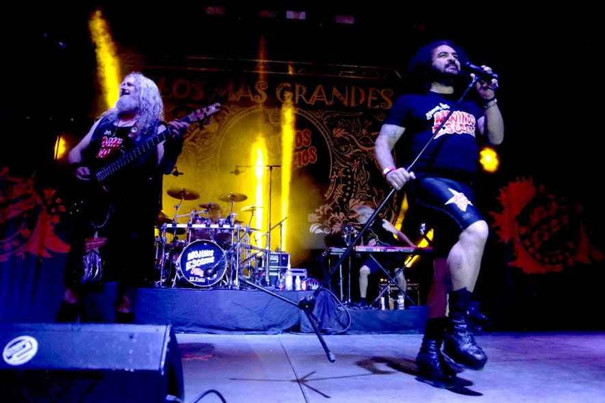 Cantante al micrófono con miembros de la banda al fondo