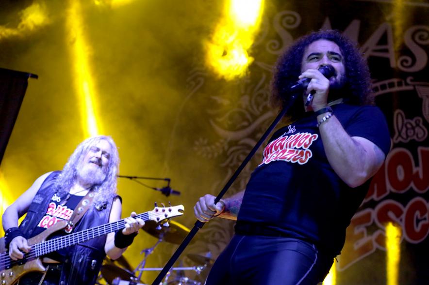 Cantante al micrófono con miembros de la banda al fondo