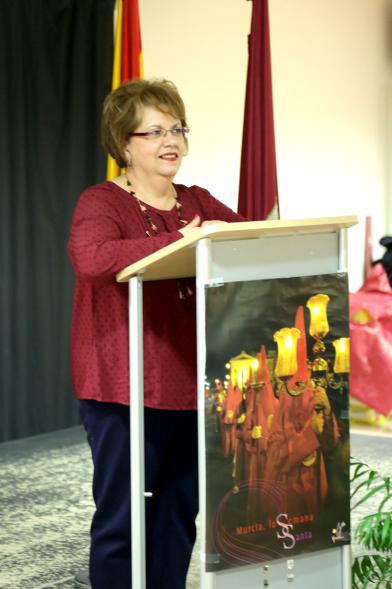 Entrega de Mona de Pascua - Imagen de una mujer en el escenario dirigiéndose a los asistentes.