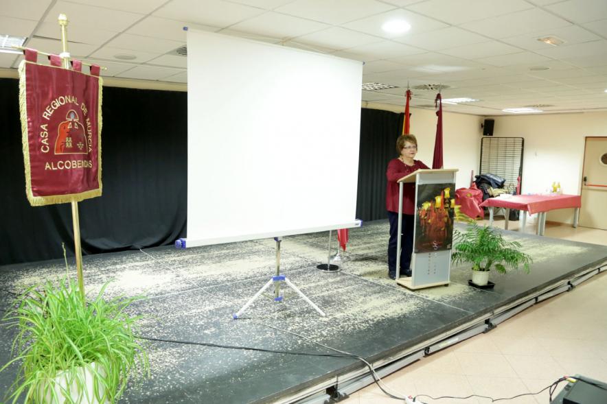 Entrega de Mona de Pascua - Imagen de una mujer en el escenario dirigiéndose a los asistentes.