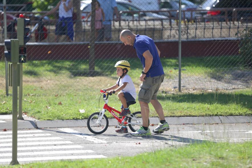 Semana Europea de la Movilidad - Tu Seguridad No Es Un Juego - Imagen de un padre con su hijo ciclista en el  circuito.