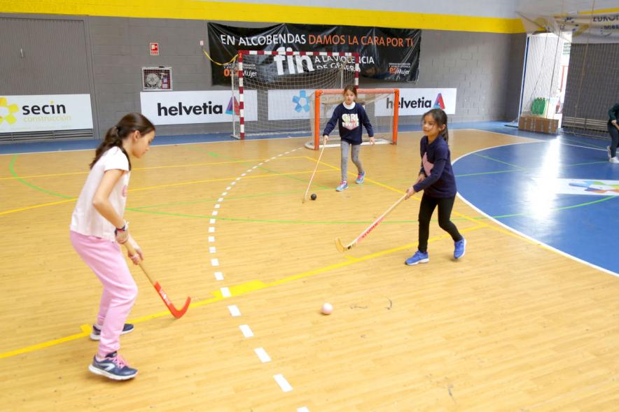 Día Multideportivo por la Integración y la Conciliación - Un grupo de niñas jugando al hockey.