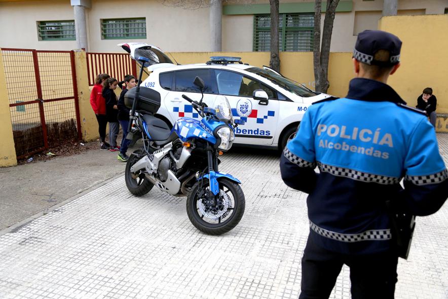 Día Multideportivo por la Integración y la Conciliación - Plano general de un policía junto a su coche y la moto.