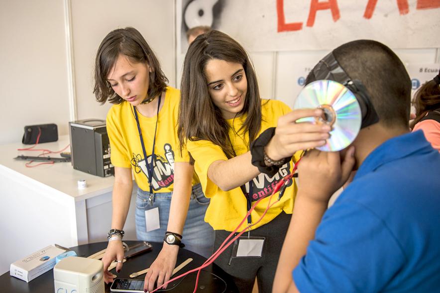 Finde Científico en MUNCYT - Dos monitoras enseñando a un niño.