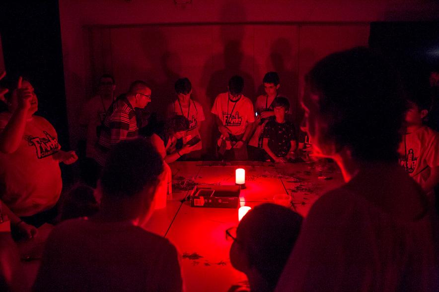 Finde Científico en MUNCYT - Grupo de jóvenes en una actividad a oscuras.