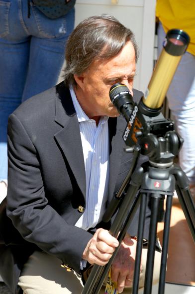 Finde Científico en MUNCYT - Primer plano del alcalde mirando por un telescopio.