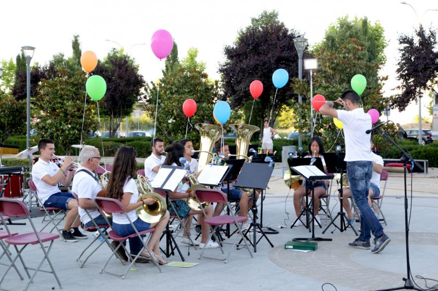 La Música Conquista la Calle - Avda Pablo Iglesias - Imagen de unos jóvenes tocando diferentes instrumentos de viento y un director de orquesta que les dirige .