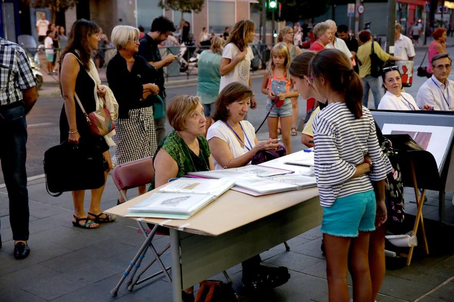 Noche en Blanco 2018 - Imagen de personas reunidas en la entrada del Centro de Arte...mirando las mesas con objetos expuestos.