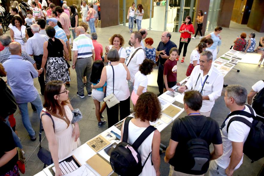 Noche en Blanco 2018 - Imagen de personas reunidas en la entrada del Centro de Arte...mirando las mesas con objetos expuestos.