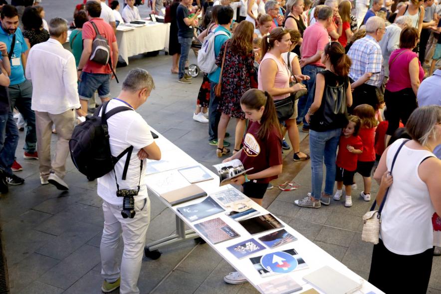 Noche en Blanco 2018 - Imagen de personas reunidas en la entrada del Centro de Arte...mirando las mesas con objetos expuestos.