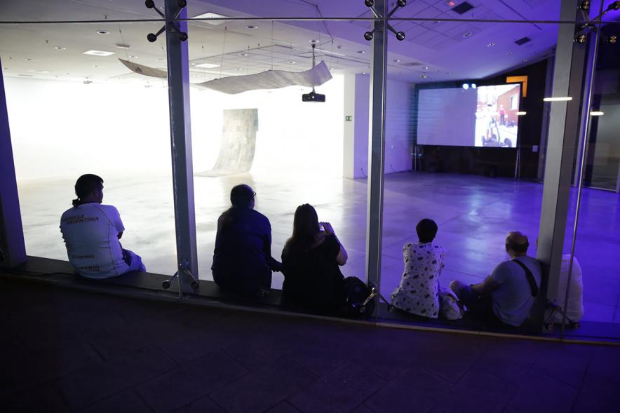 Noche en Blanco 2018 - Imagen de personas mirando una proyección en una sala.