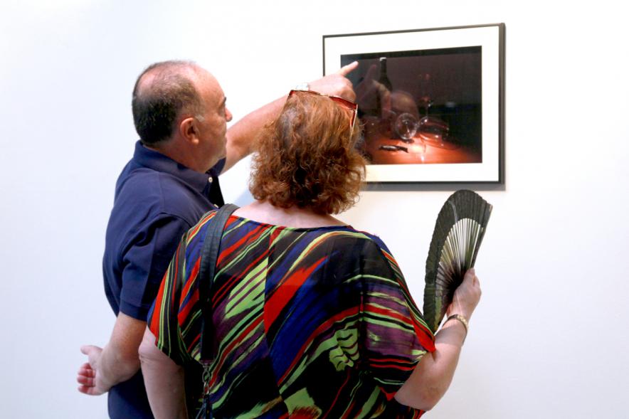 Inauguración Exposición "Objetos Iluminados" de A Contraluz - Imagen de personas admirando una fotografía de la exposición.