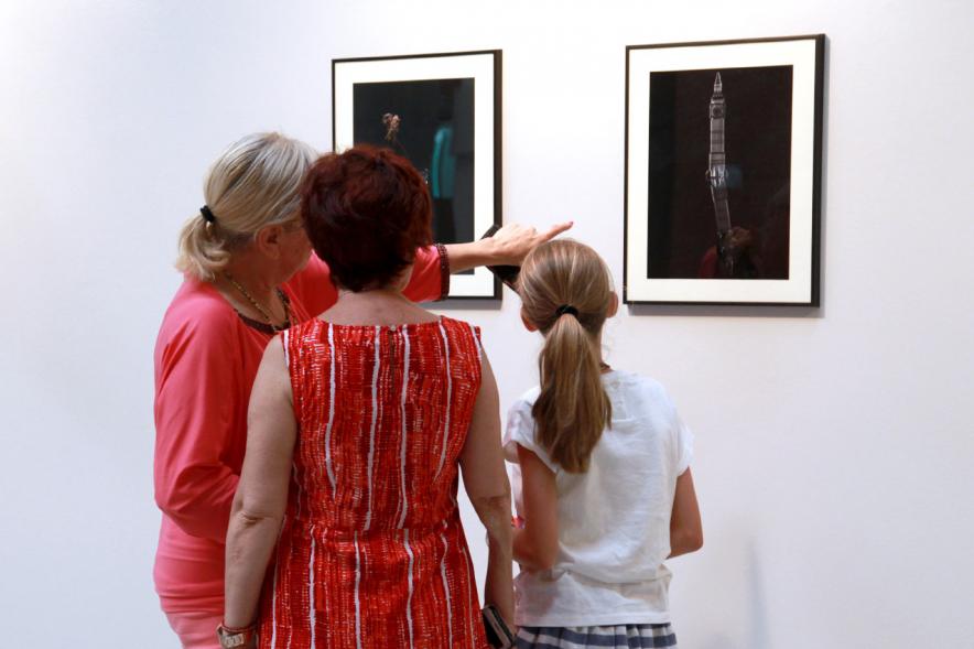 Inauguración Exposición "Objetos Iluminados" de A Contraluz - Imagen de personas admirando unas fotografías de la exposición.