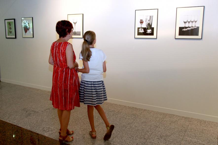 Inauguración Exposición "Objetos Iluminados" de A Contraluz -  Imagen de personas admirando unas fotografías de la exposición.