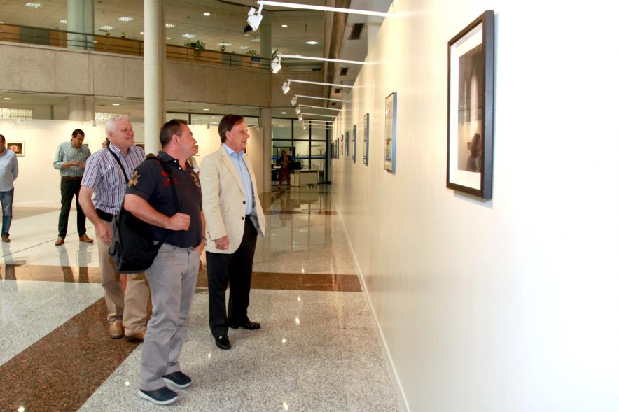 Inauguración Exposición "Objetos Iluminados" de A Contraluz - Imagen del alcalde García de Vinuesa y otras personas admirando las fotografías expuestas.