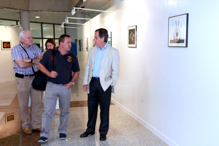 Inauguración Exposición "Objetos Iluminados" de A Contraluz - Imagen del alcalde García de Vinuesa charlando con uno de los artistas que exponen sus fotografías.