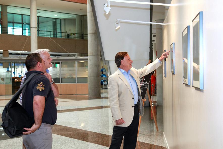 Inauguración Exposición "Objetos Iluminados" de A Contraluz - Imagen del alcalde García de Vinuesa y otras personas admirando las fotografías expuestas.