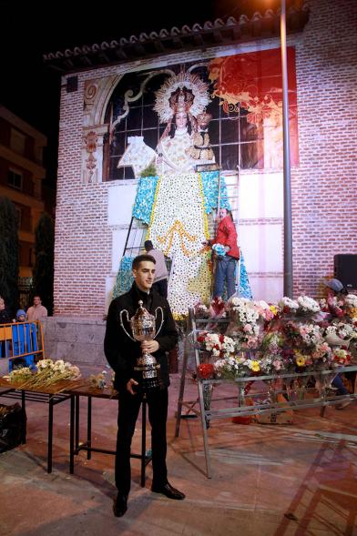 Ofrenda Floral a la Virgen de La Paz 2017 - Imagen de una persona posando delante del manto de flores de la virgen.
