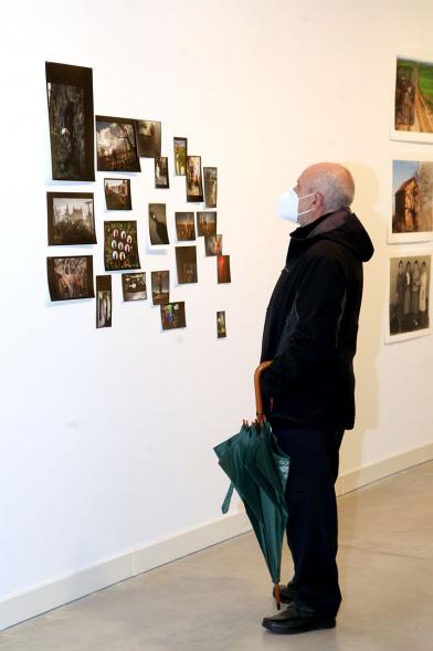 Inauguración Exposición "Encuentros en Tiempo Presente" - Master PIC.A - Imagen de un visitante con mascarilla observando un collage de obras pequeñas.