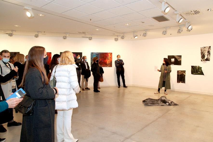 Inauguración Exposición "Encuentros en Tiempo Presente" - Master PIC - Imagen de la responsable de la exposición dando información sobre ella, con mascarilla..A - Imagen de la responsable de la exposición dando información sobre ella, con mascarilla.