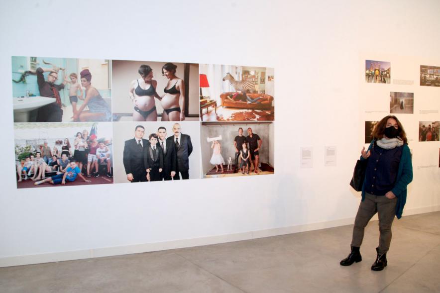 Inauguración Exposición "Encuentros en Tiempo Presente" - Master PIC.A - Primer plano de una visitante junto a un grupo numeroso de fotografías  expuestas.